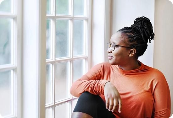 A woman sitting next to windown and looking out