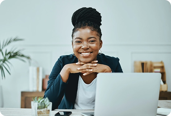 Woman smiling with a laptop in front of her