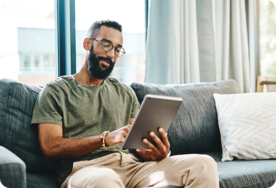 Male sitting on the couch with an iPad