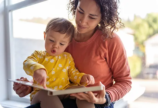 Woman sitting and reading a book with a child