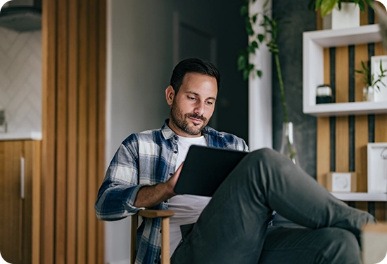 Male sitting in chair with his iPad