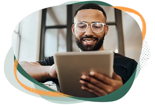 Hombre sentado sonriendo frente a su iPad